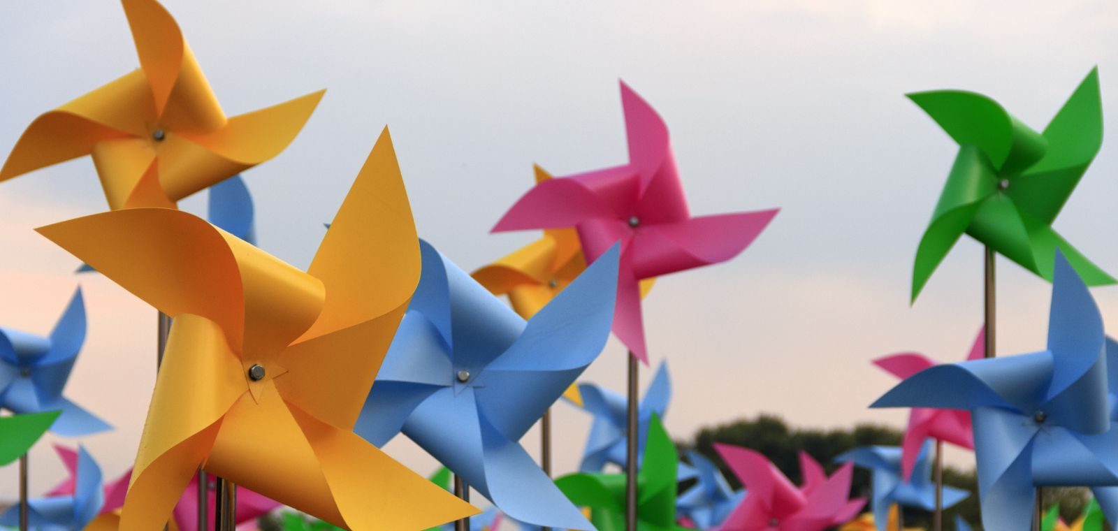 Pinwheels against a blue sky that evoke images of wind turbines